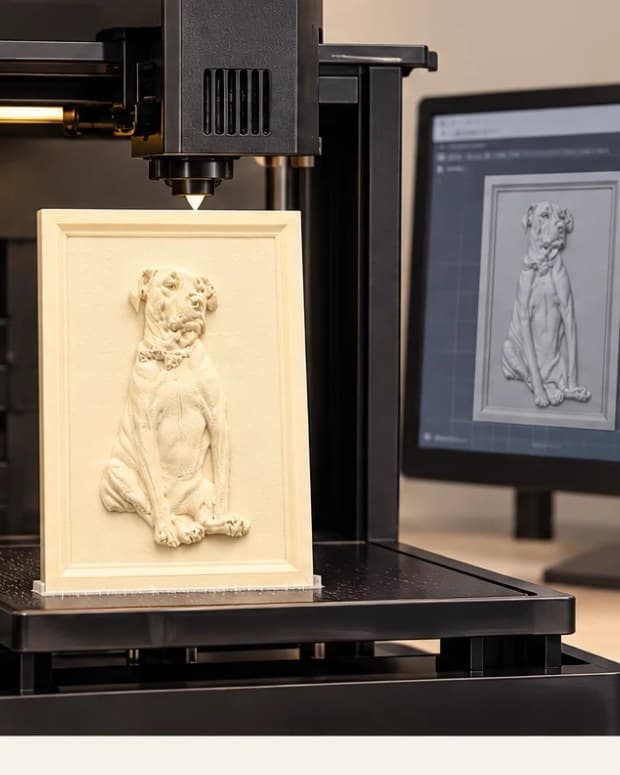 A 3D printer printing a pet relief, with the 3D model shown on screen